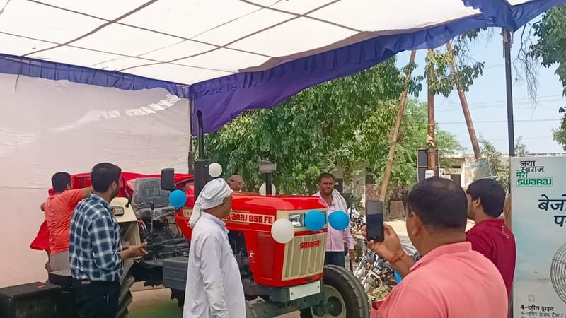 Farmers at a Swaraj customer meet with an emcee on stage